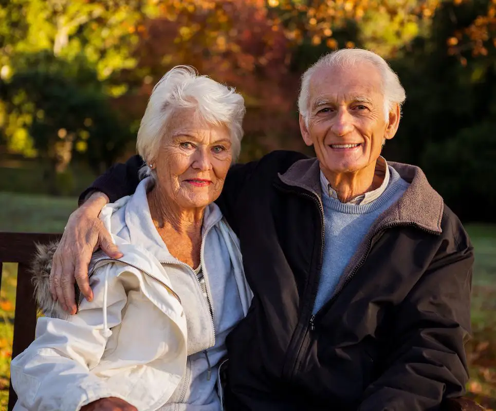 Elderly couple sitting on a bench at park